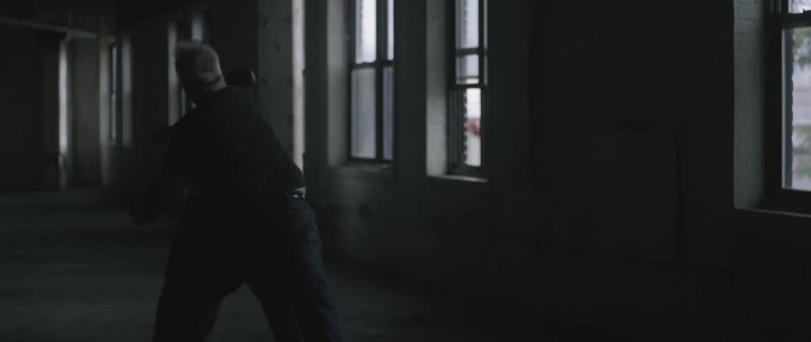 Two men fight in the dark building