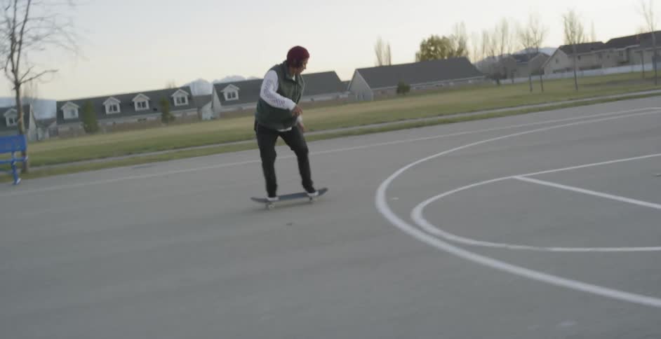 A man misses a jump on his skateboard in the park