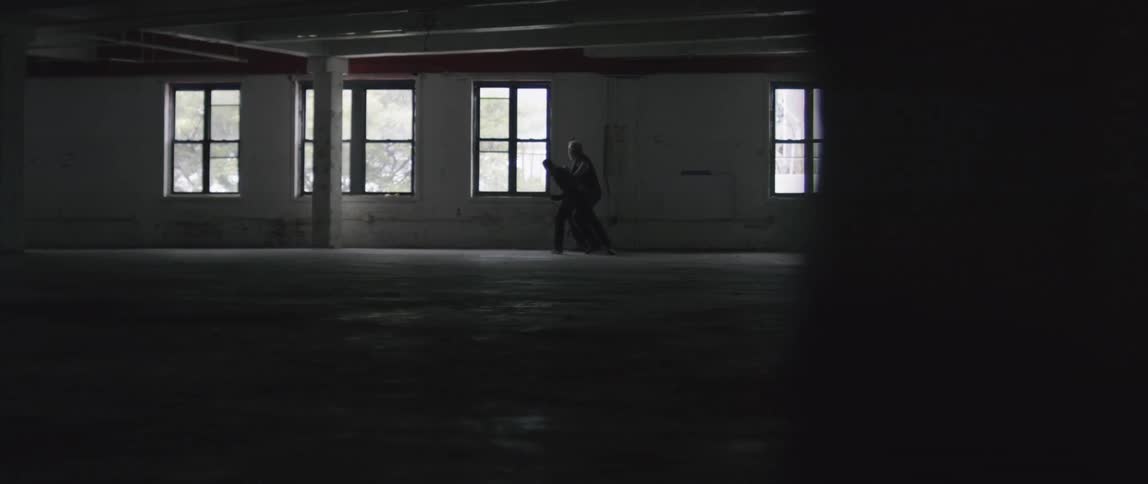 Man swings a punch and misses another man in empty building