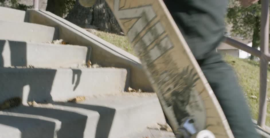 A man carries his skateboard up the steps