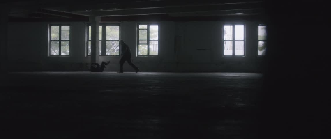 A man is punched and knocked down in the dark building