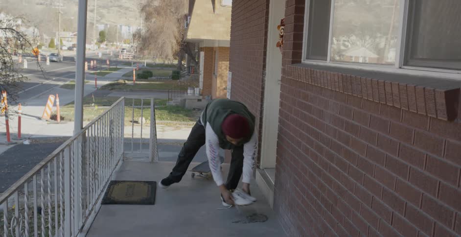 A man skateboards in front of a front door