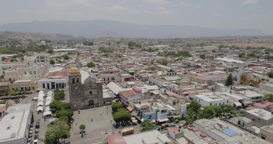 Buildings and streets of a town with a hill on the horizon