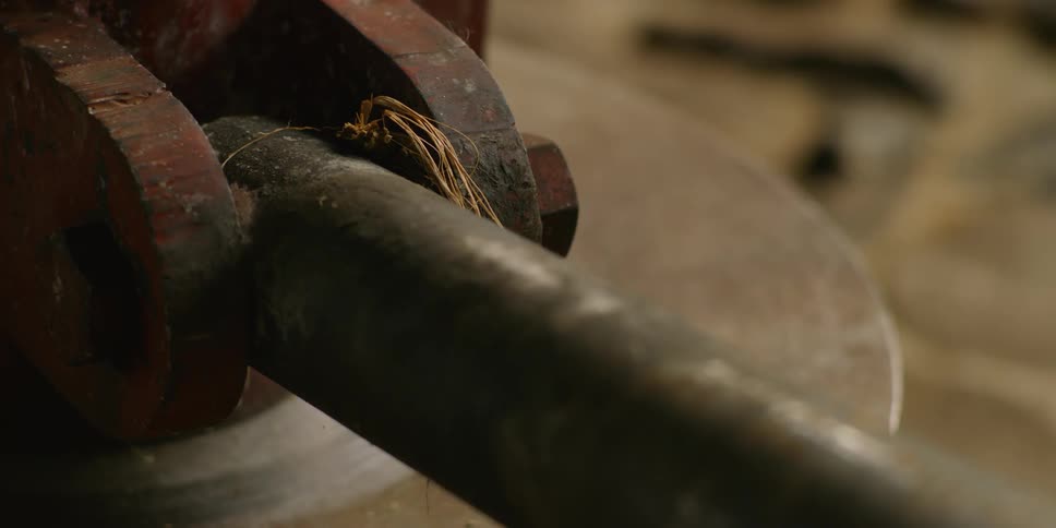 Rusty nut and bolt secures a long black tool