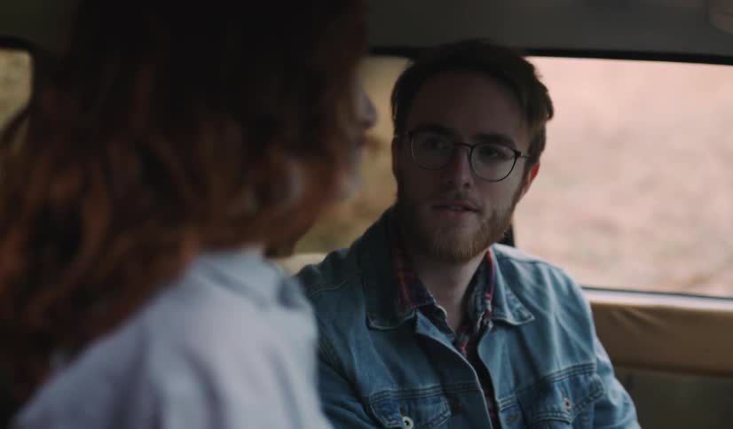 Woman in vehicle turns toward the man next to her during the day