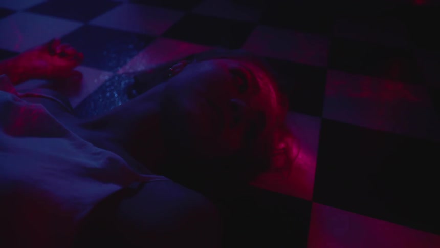A woman lays on a checkered floor