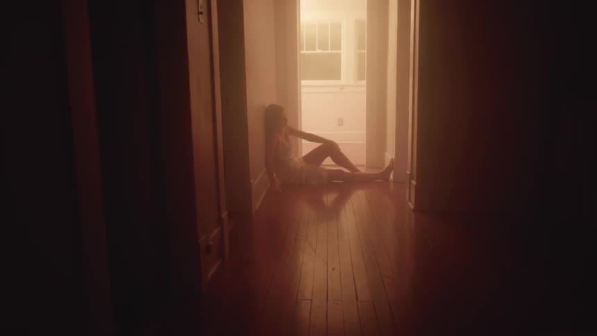 A person is sitting in a hallway of a house