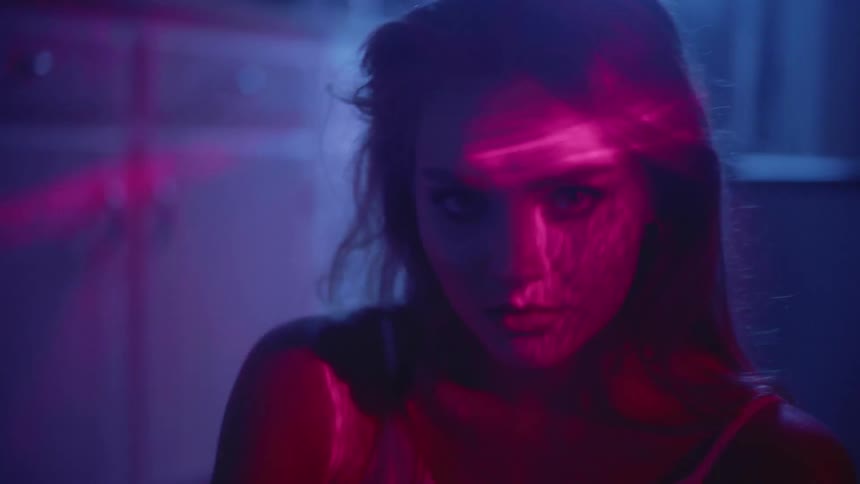 Girl Looks into camera while red lights shine on her