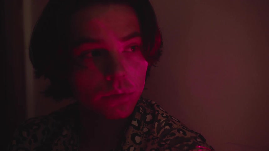 A woman looks to her side in the dark hall