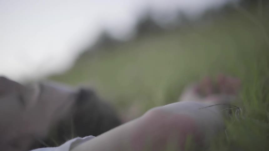 A woman is lying in the grass