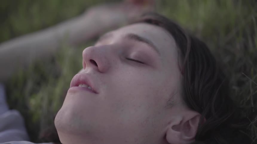 A man is resting in the grass