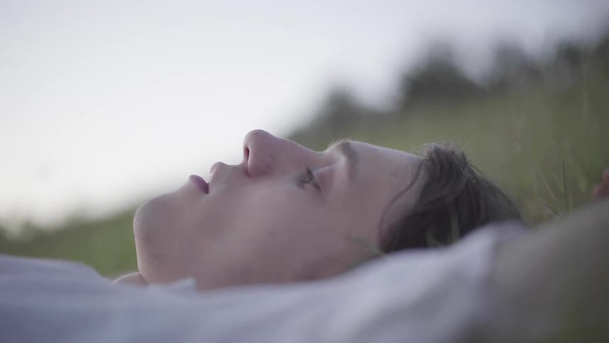 A man is laying down in the grass