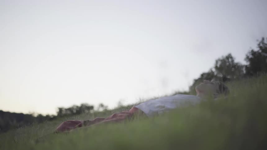 A man gets up from laying on the grass