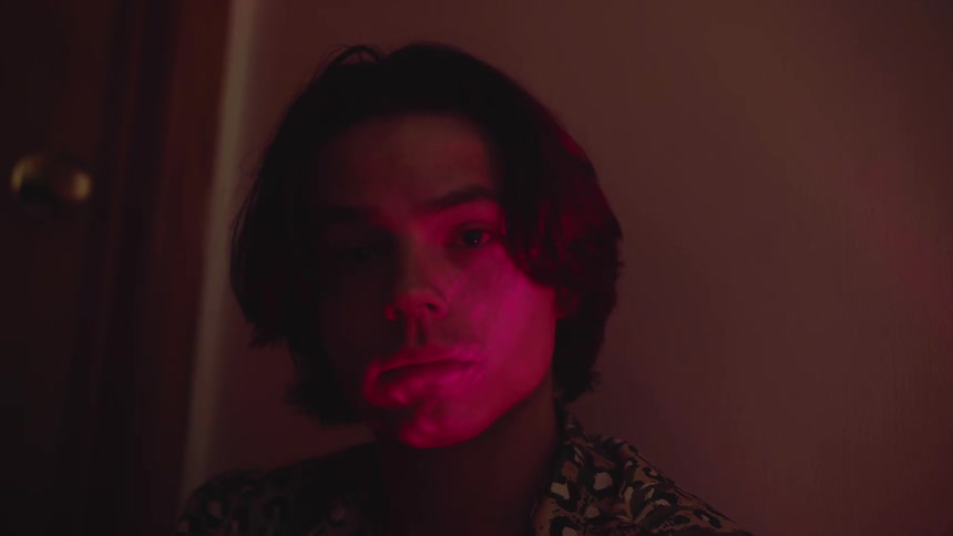 A man is in a dark room with red light shining