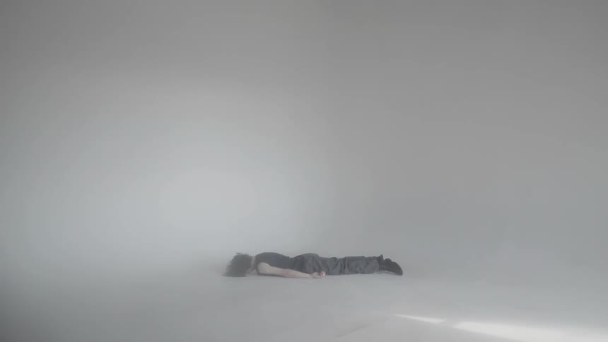 A man lays on the ground in the studio