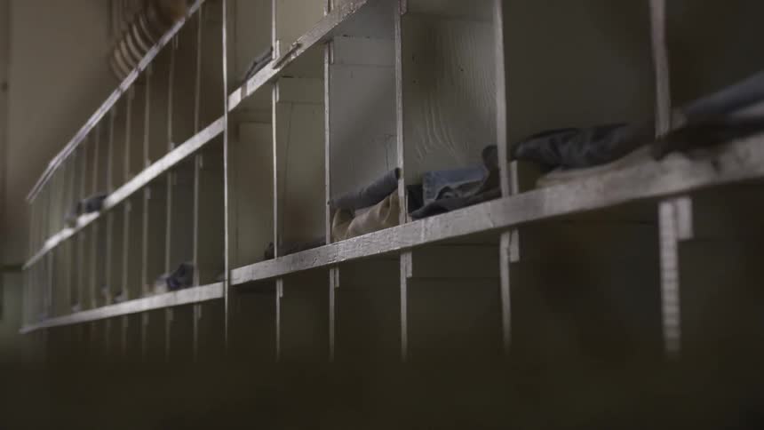 A long row of cubicles with clothing inside