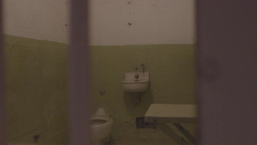 Bathroom in a prison with walls that are half green and half white