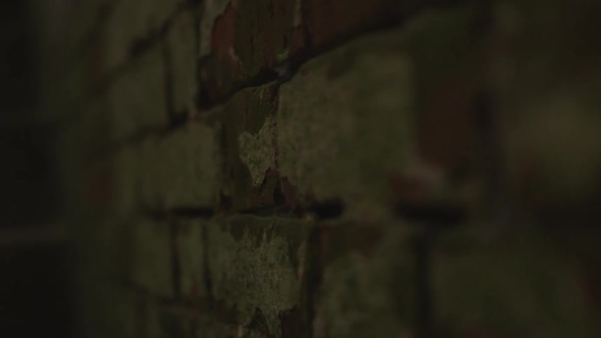 The wall of the dark room is made of brick