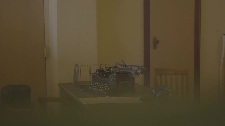 A typewriter sitting on a table next to a rotary phone