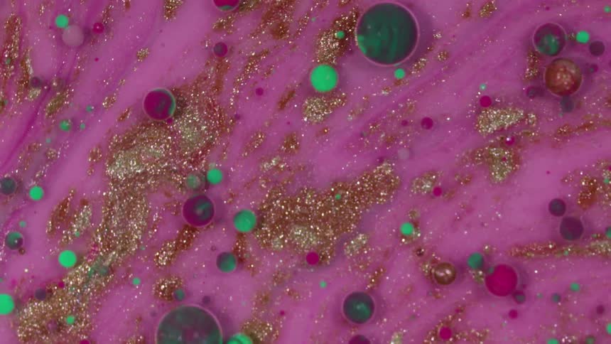 Pink goop swirling with glitter and marbles