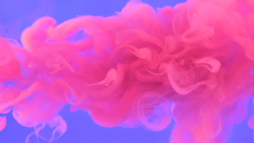 Pink smoke drifts in front of a blue background