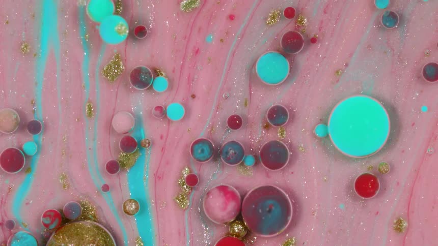 Marbles float in thick blue and pink liquid