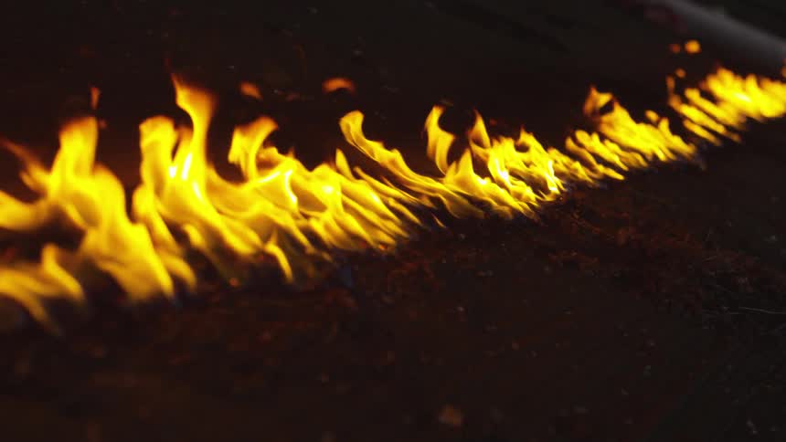 Line of flames burns brightly at night