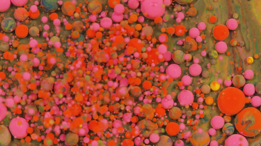 The different colored paint float around in the liquid