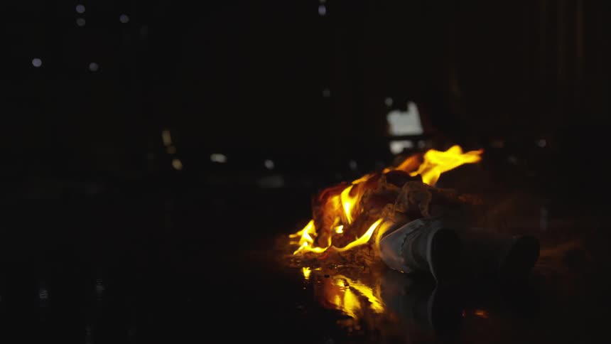 The doll is burning on the ground