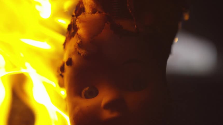 The doll burns and melts to the ground