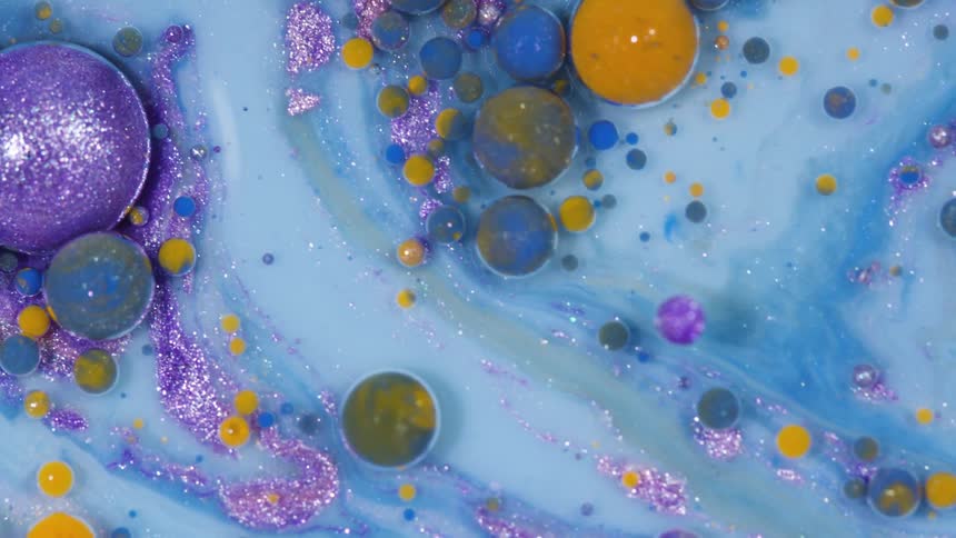 Colorful bubbles float on the surface of a blue liquid