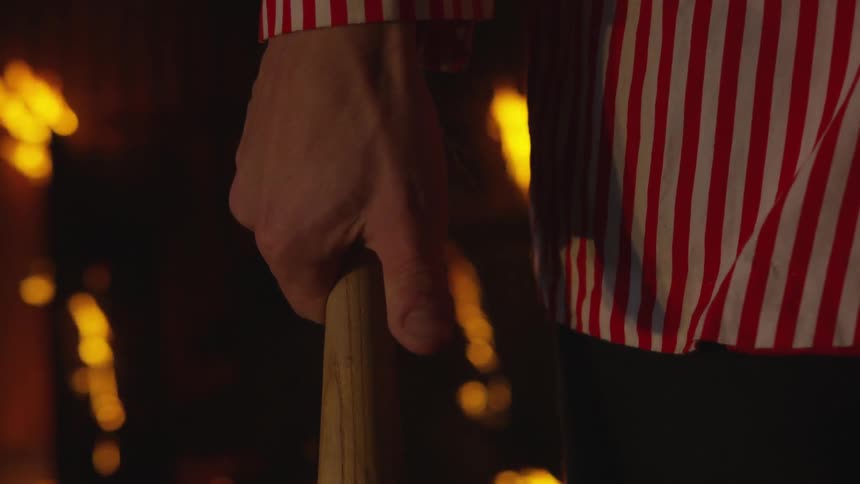 A man is holding a bat in a burning building