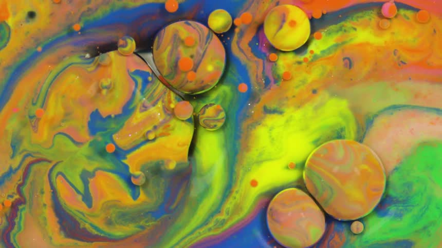 Multiple colors of paint swirling in a milky liquid