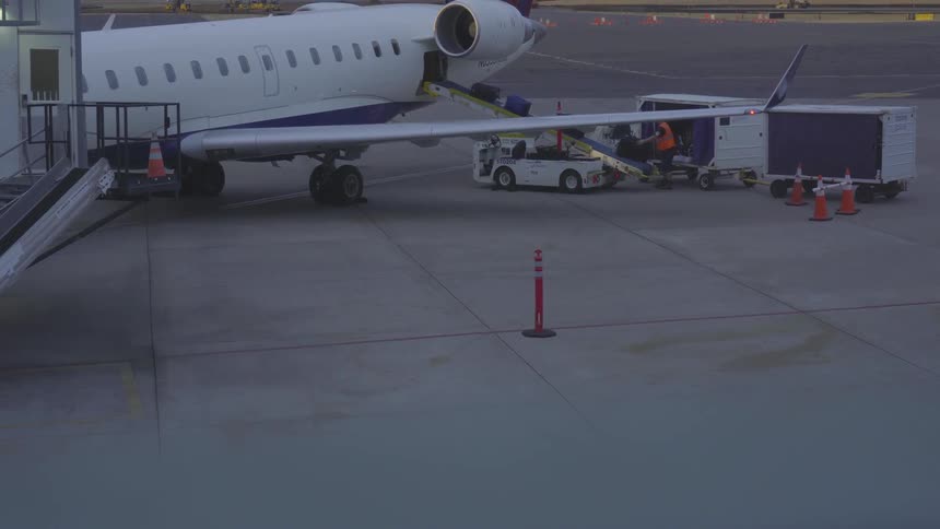 Luggage being loaded onto an airplane on tarmac