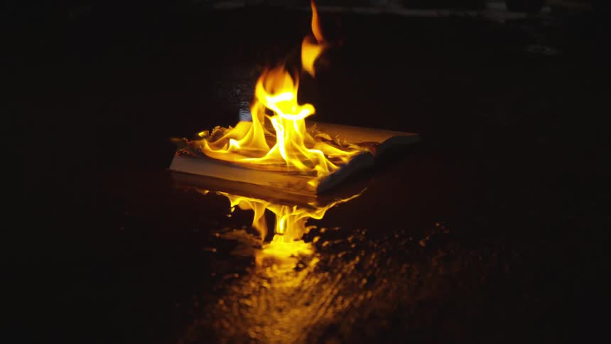 The book burns slowly on the dark floor