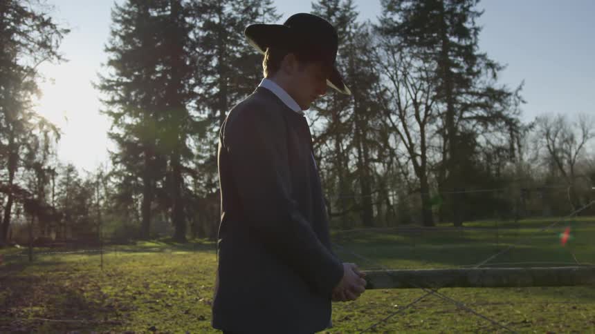 A man is praying outdoors in the sunlight