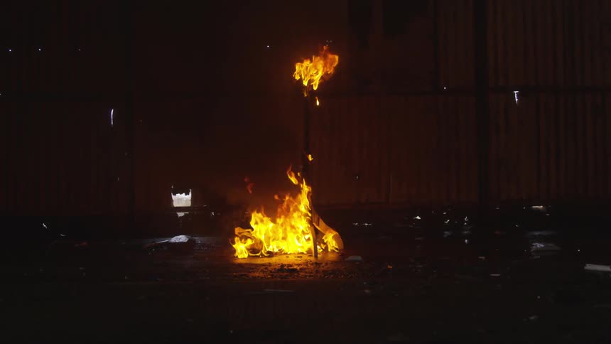 Fire burns at the bottom and top of a pole