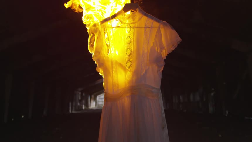 A white dress on a hanger is on fire