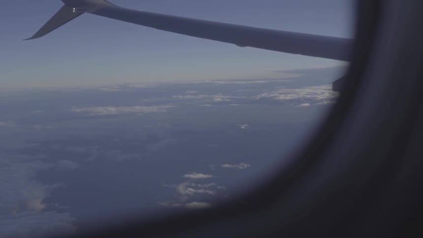 Looking at the clouds out of the window of an airplane