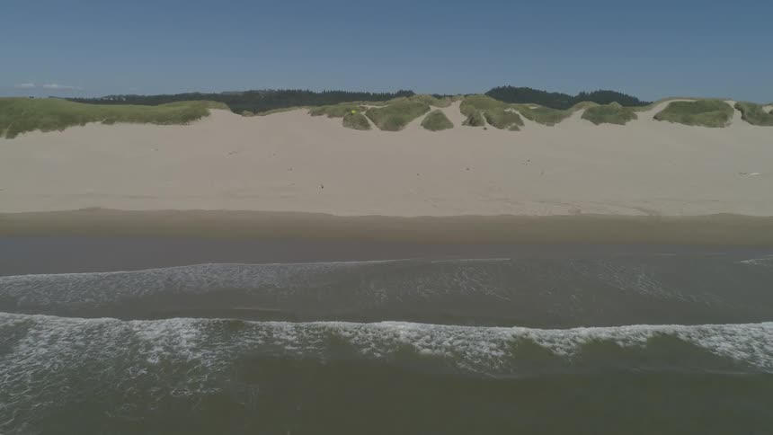 Ocean waves flow towards a sandy shore