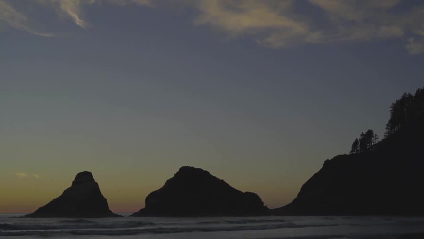 Large rocky islands in the ocean at sunset