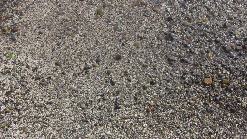 Clear water ebbs onto a shingle surface