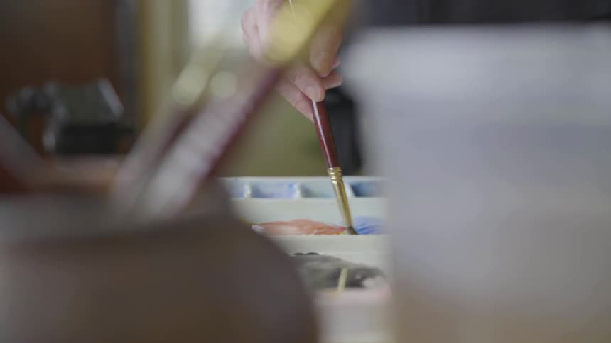 An artist mixes paint together