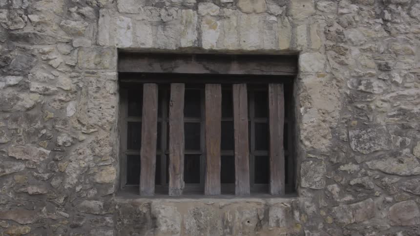 Wooden slats on a window set into a stone wall
