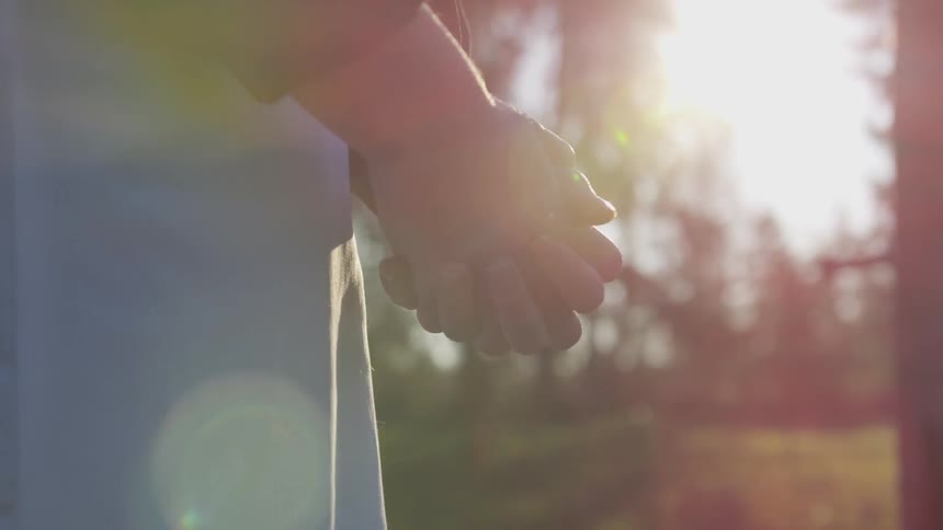 A person is holding their hands together outdoors