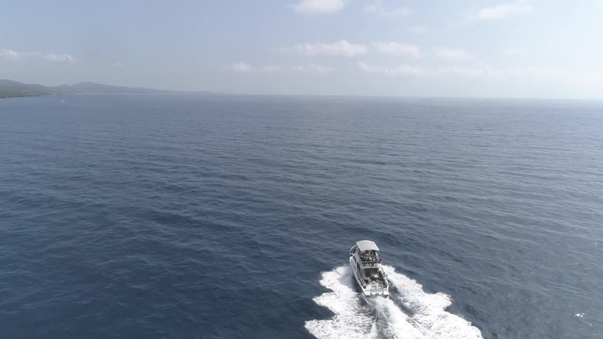 A large boat riding into the open ocean