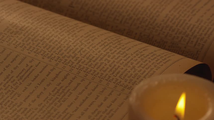 A lit candle by a book
