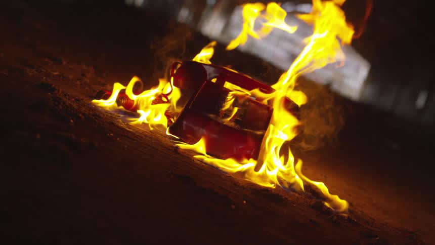 An old phone rapidly burns on the ground at night