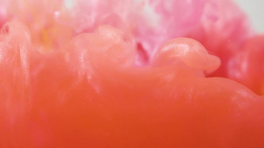 A pink ink moves around the clear liquid
