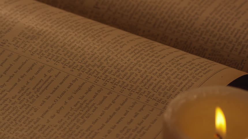 A lit candle by a book